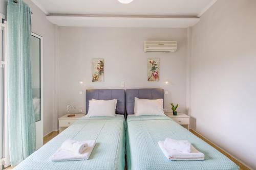 a bedroom with two beds with towels on them at Andreas Hideaway Palaiokastritsa in Paleokastritsa