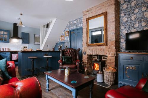 a living room with a fireplace and a tv at Bronte's Rest - Detached Elegant Cottage in Historic Old Town with Garden in Scarborough