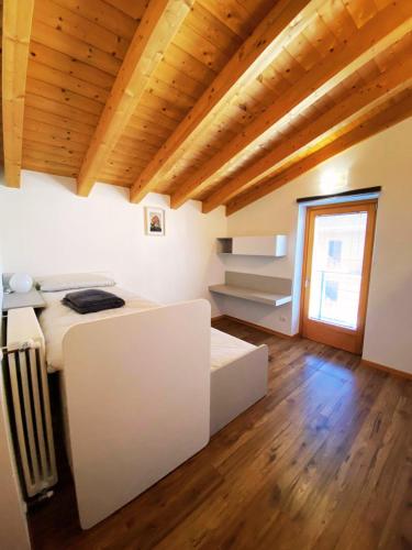a bedroom with a white bed and a wooden ceiling at Ca' Berti Teglio in Teglio