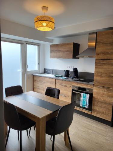 une cuisine avec une table et des chaises dans une pièce dans l'établissement Un Bibou de Campagne 3, à Le Theil-de-Bretagne