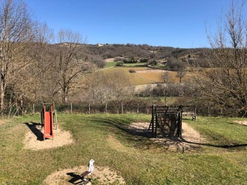 a person standing in a field with a playground at Maison de village chaleureuse Verfeil sur Seye 82 in Verfeil-sur-Seye