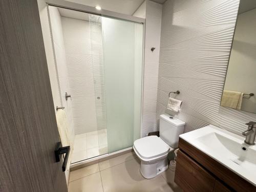 a bathroom with a toilet and a sink and a mirror at Luxurious and Spacious Family Apartment in Curupau Isuto in Santa Cruz de la Sierra