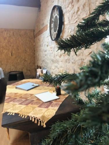 a table with a christmas tree and a clock on a wall at Maison de village chaleureuse Verfeil sur Seye 82 in Verfeil-sur-Seye