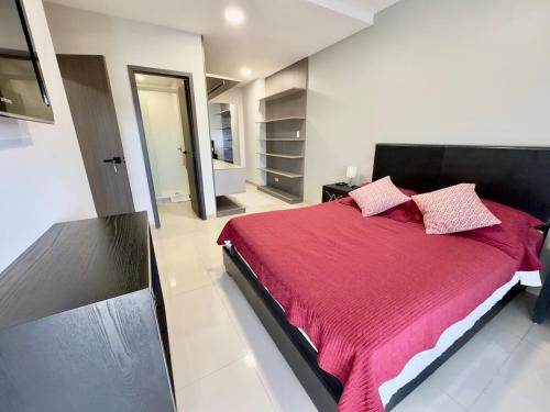 a bedroom with a large bed with a red blanket at Luxurious and Spacious Family Apartment in Curupau Isuto in Santa Cruz de la Sierra