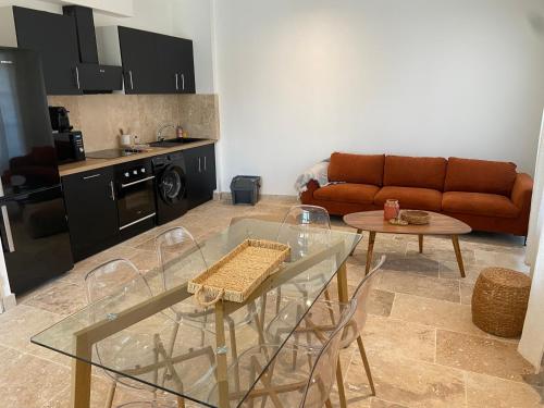 un salon avec une table en verre et un canapé dans l'établissement Maison Goya Arlésienne, à Arles