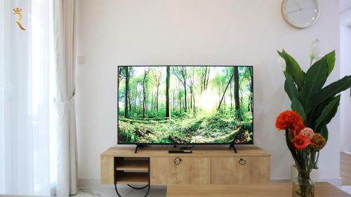 a flat screen tv sitting on top of a wooden entertainment center at Azure Serenity 1BR - Chic Coastal Escape in Abu Dhabi