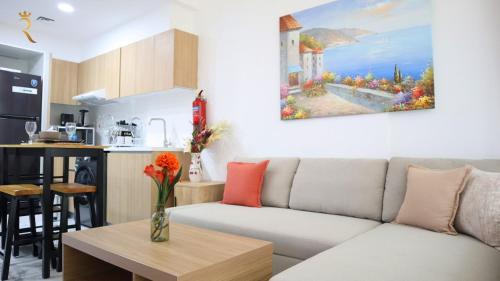 a living room with a couch and a kitchen at Azure Serenity 1BR - Chic Coastal Escape in Abu Dhabi
