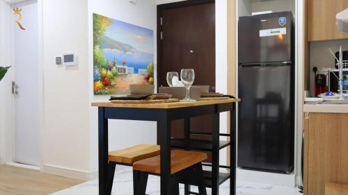 a kitchen with a counter with a table and a refrigerator at Azure Serenity 1BR - Chic Coastal Escape in Abu Dhabi