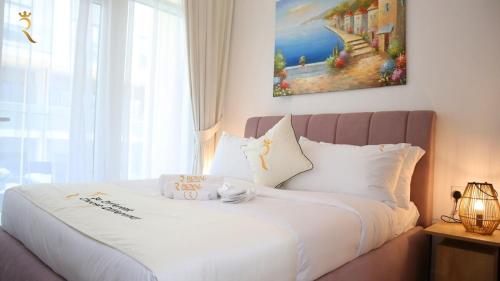 a bedroom with a white bed with a large window at Azure Serenity 1BR - Chic Coastal Escape in Abu Dhabi