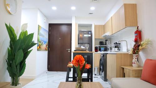 a kitchen and a living room with a table with flowers at Azure Serenity 1BR - Chic Coastal Escape in Abu Dhabi