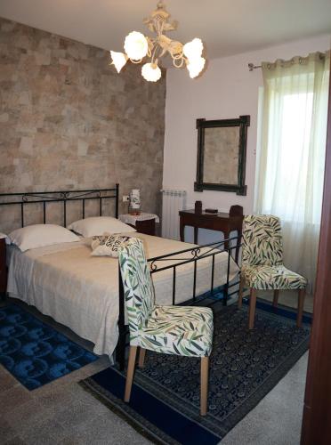 a bedroom with a bed and two chairs at Casa Vacanze Cimorelli in Venafro