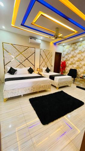 two beds in a room with two rugs at Holiday Guest House Lahore in Lahore