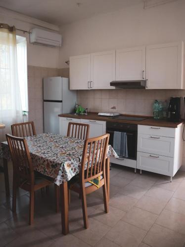 a kitchen with a table and chairs and a kitchen with white cabinets at Casa Vacanze Cimorelli in Venafro