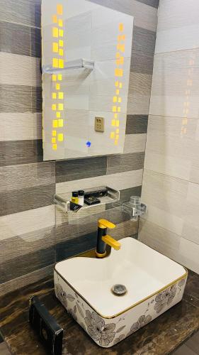 a bathroom with a white sink and a mirror at Holiday Guest House Lahore in Lahore