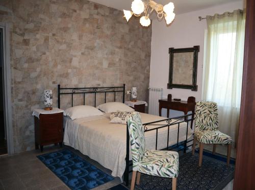 a bedroom with a bed and two chairs at Casa Vacanze Cimorelli in Venafro