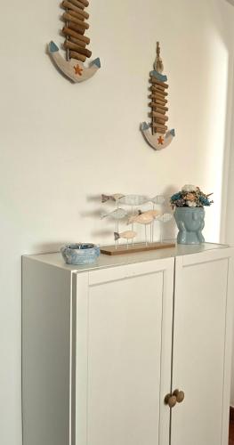 a white cabinet with plates and bowls on top of it at JB House in Peniche