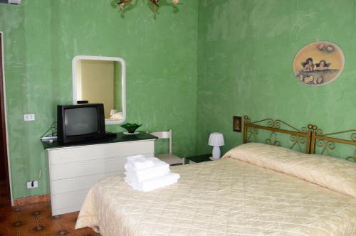 アルベロベッロにあるVilla Nonna Mimmaのベッドルーム(ベッド1台、テレビ、鏡付)