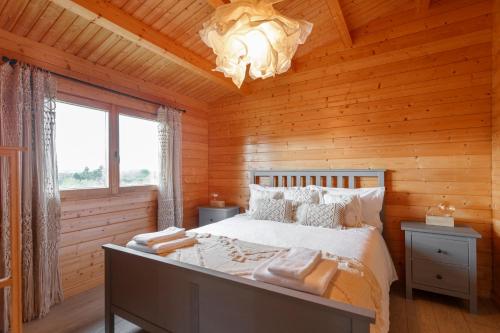 a bedroom with a bed in a wooden cabin at Quinta da Relva - Soulful House in Mafra