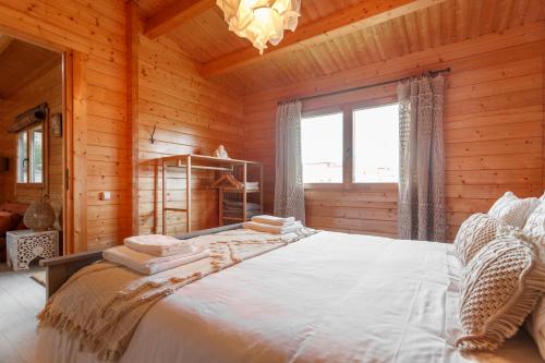 a bedroom with a large bed in a wooden room at Quinta da Relva - Soulful House in Mafra