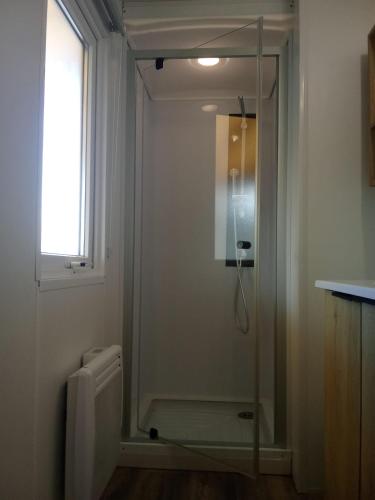 une douche avec une porte vitrée dans une salle de bain dans l'établissement Mobile home cosy 6 personnes!, à Canet