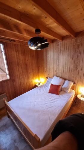 Cette chambre en bois comprend un grand lit. dans l'établissement Le Nid du Lac, à Moux-en-Morvan