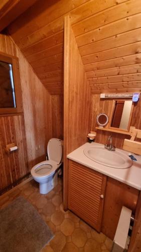 La salle de bains en bois est pourvue de toilettes et d'un lavabo. dans l'établissement Le Nid du Lac, à Moux-en-Morvan