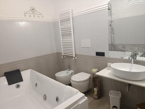 a white bathroom with a sink and a toilet at Relais Tiaré Bed and Breakfast in Bacoli