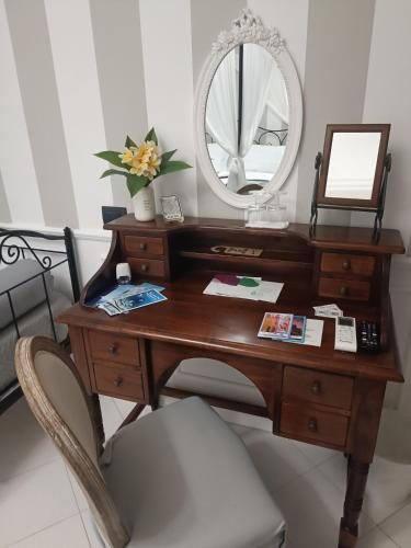 a wooden desk with a mirror and a chair at Relais Tiaré Bed and Breakfast in Bacoli