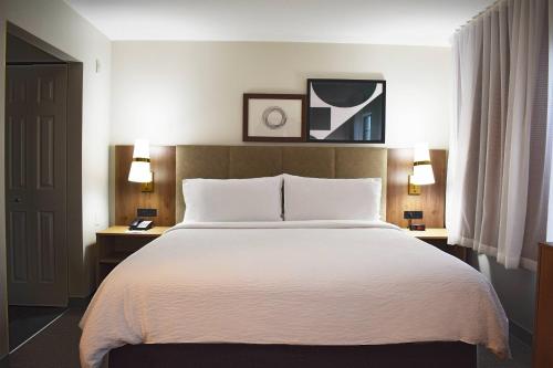 a bedroom with a large white bed with two night stands at Staybridge Suites Detroit-Novi by IHG in Novi