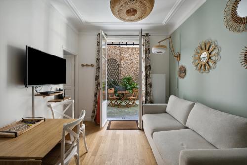 a living room with a couch and a table at La Maison Kléber - Luxury apartments, Champs-Elysées - Eiffel Tower in Paris