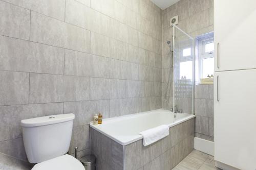 y baño con aseo, bañera y bañera. en Trendy Spacious 1 Bedroom Flat, en Londres