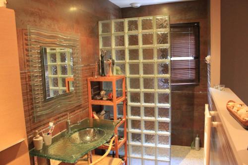 La salle de bains est pourvue d'un lavabo et d'une paroi en verre. dans l'établissement Maison cottage, à Rochefort-du-Gard