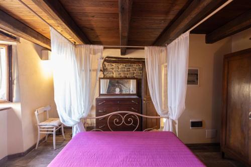 a bedroom with a bed with a pink bedspread at Canto del Fiume in Ortignano Raggiolo