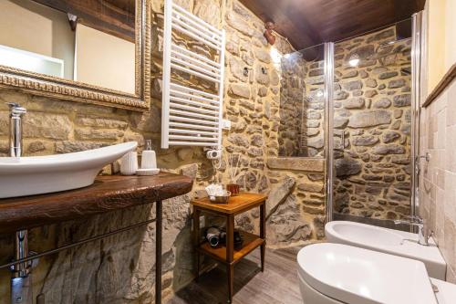 a stone bathroom with a sink and a toilet at Canto del Fiume in Ortignano Raggiolo