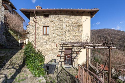 a small stone house with a fence in front of it at Canto del Fiume in Ortignano Raggiolo