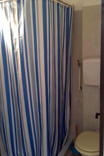 a bathroom with a shower curtain and a toilet at Guest house Mira in Pirovac