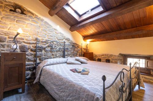 a bedroom with a large bed in a stone wall at Canto del Fiume in Ortignano Raggiolo