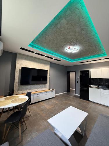 a living room with a table and a large screen tv at Apartament Centrum 3-pokojowy Klimatyzacja nr 4 in Radom