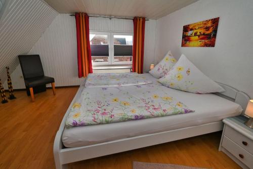 een slaapkamer met een bed, een raam en een stoel bij Haus-Karin-Ferienwohnung-1 in Büsum
