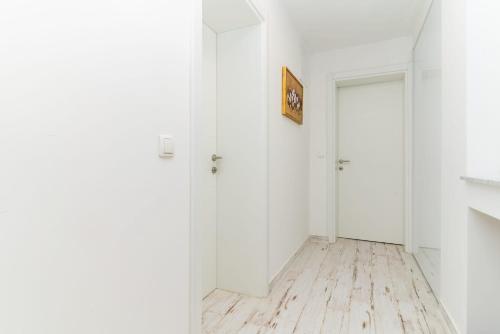 an empty hallway with white walls and wood floors at Bogdanović Winery Apartman in Ilok