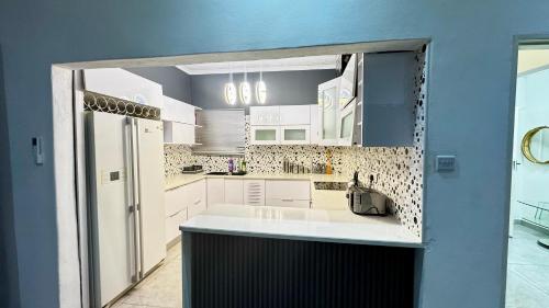 a kitchen with white cabinets and a large sink at CBD sanctuary-self catering in Gaborone