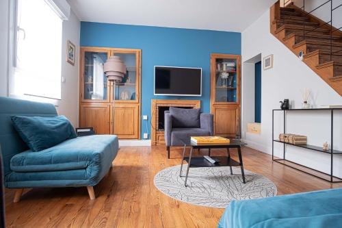 - un salon avec des murs bleus, un canapé et une chaise dans l'établissement TRIPLEX cathédrale parking gratuit, à Reims