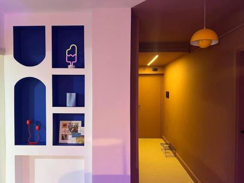 a hallway with blue and yellow walls and a chair at Le Nid Des Couleurs in 'Aïn Taya