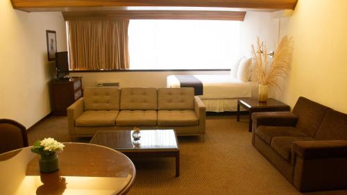 a living room with a couch and a bed at J&A Classic Hotel in Lima