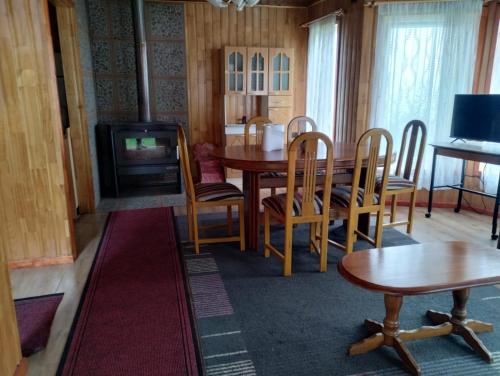a dining room with a table and chairs and a television at 5mentarios Ltda in Dalcahue