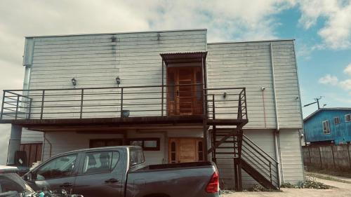 a house with a truck parked in front of it at 5mentarios Ltda in Dalcahue