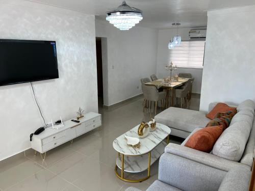 a living room with a couch and a flat screen tv at Olympus Paradise in Juan López