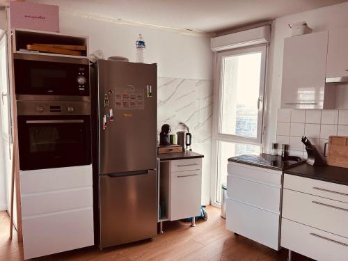 Il comprend une cuisine équipée d'un grand réfrigérateur en acier inoxydable. dans l'établissement Appartement T3 avec grand balcon, à Bordeaux