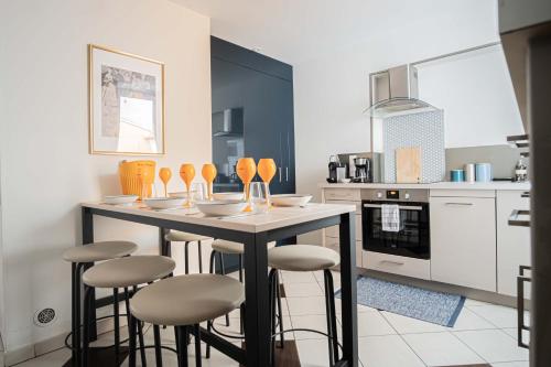 - une cuisine avec une table et des tabourets de bar dans l'établissement TRIPLEX cathédrale parking gratuit, à Reims