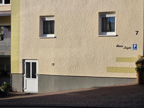a building with a white door and two windows at Ferienwohnung Haus Luzia in Düngenheim